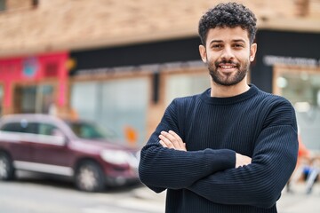 Fototapeta premium Young arab man smiling confident standing with arms crossed gesture at street