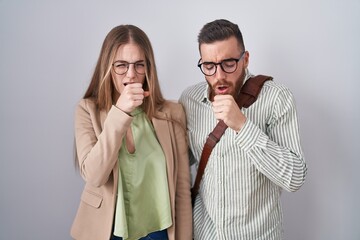 Young couple standing over white background feeling unwell and coughing as symptom for cold or bronchitis. health care concept.