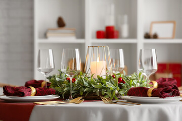 Christmas table setting with mistletoe wreath in dining room