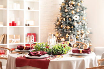 Christmas table setting with mistletoe wreath in dining room