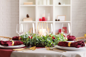 Christmas table setting with mistletoe wreath in dining room