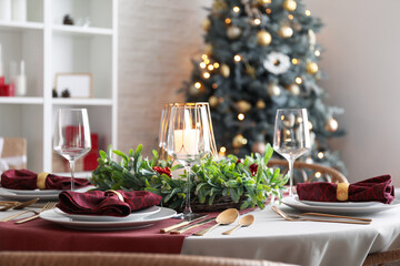 Christmas table setting with mistletoe wreath in dining room