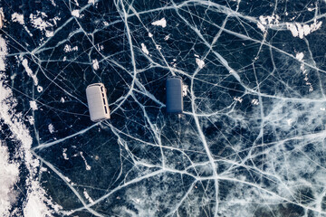 Travel winter lake Baikal. Clear ice surface with cars buses with tourists parked, aerial top view