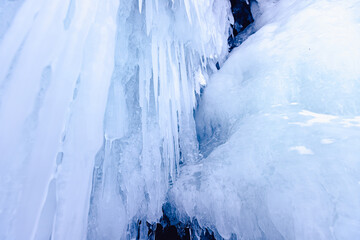 Naklejka na ściany i meble Blue ice cave grotto lake Baikal Olkhon island, Russia. Frozen clear icicles, beautiful winter landscape