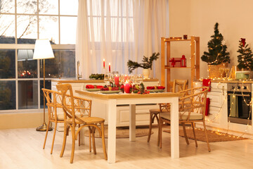 Interior of kitchen with dining table, candles and Christmas trees