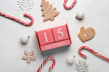 Cube calendar with date 15 DECEMBER, Christmas decor and cookies on light background