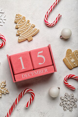 Cube calendar with date 15 DECEMBER, Christmas decor and cookies on light background