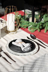 Christmas table setting with black plate in dining room, closeup