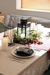 Christmas table setting with wreath and candles in dining room