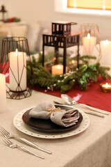 Christmas table setting with black plate in dining room, closeup