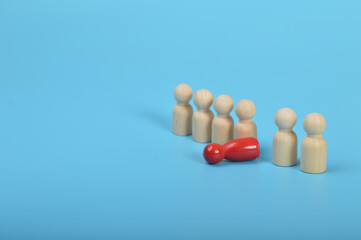 Dismissal, layoff, unemployment, employment stress. Red wooden figure overturns row group of workers.