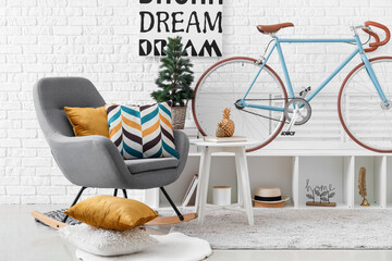 Interior of living room with bicycle, shelving unit and small Christmas tree