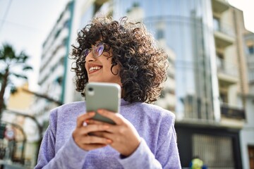 Young middle east woman smiling confident using smartphone at street © Krakenimages.com
