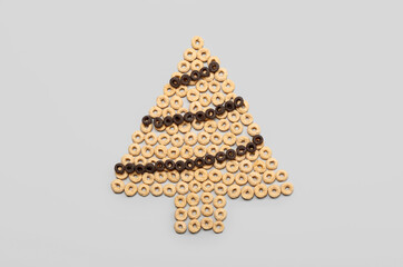 Christmas tree made of cereal rings on grey background