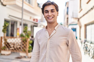 Young caucasian man smiling confident standing at coffee shop terrace