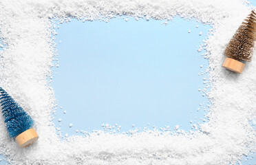 Frame made of artificial snow and Christmas decorations on color background