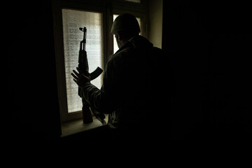 Conceptual photo of war between Russia and Ukraine. Ukraine and Russia flags on windowsill at night. Old creepy room with window.