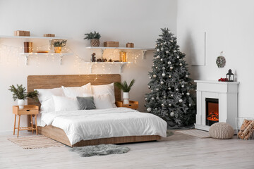 Interior of bedroom with Christmas tree, fireplace and glowing lights