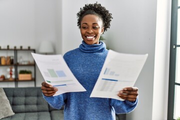 African american woman reading document standing at home