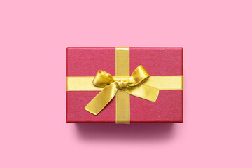 Christmas gift box with bow on pink background