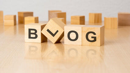 four wooden blocks with text BLOG on table. copy space. white background.