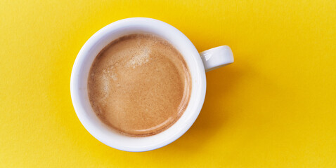  One cup of coffee with milk over yellow background