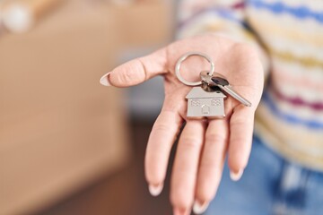 Young caucasian woman holding key at new home