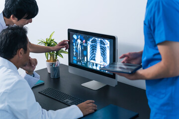 パソコンを見て会議する医療従事者のグループ