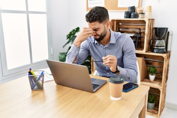 Young arab man stressed using laptop working at office