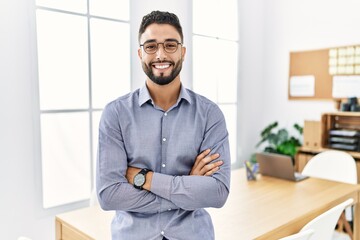 Young arab man smiling confident standing with arms crossed gesture at office