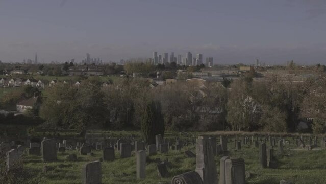 UK Financial District Looms on Horizon with Cemetery with Gravestones in the Foreground