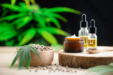 Cannabis and cosmetic concept features with set of CBD oil bottles, cream jar, and wooden bowl of...