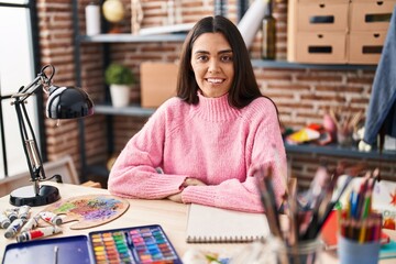 Fototapeta premium Young hispanic woman smiling confident drawing on notebook at art studio