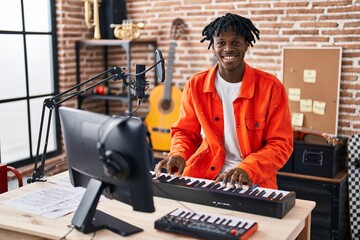 African american man musician playing piano keyboard at music studio