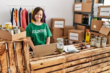 Brunette woman with down syndrome working using laptop at donations stand