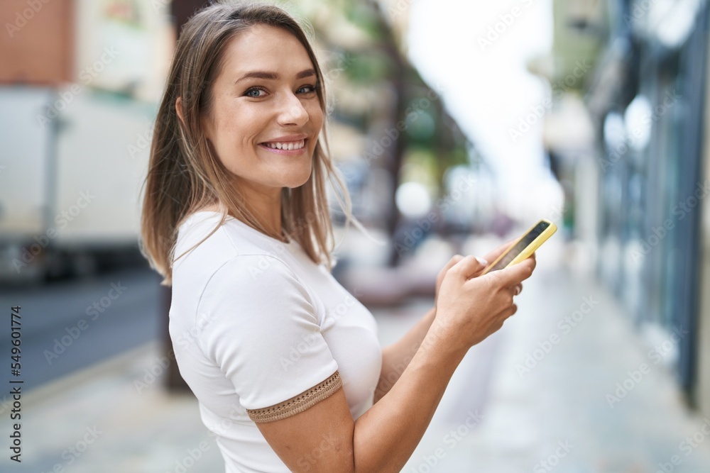 Sticker young caucasian woman smiling confident using smartphone at street