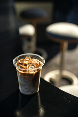 Fototapeta na wymiar ice latte coffee in plastic glass on black table at cafe​