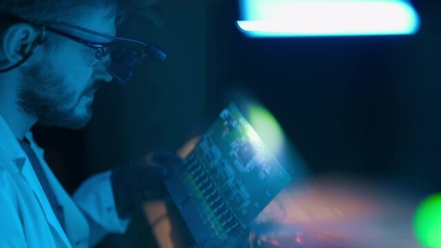 Technician engineer developer is soldering iron pcb microcircuit electronic component though magnifier. Electronic renovation scientist in repair shop. Technology science or computer hardware concept