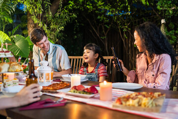Multi-ethnic big family having fun, enjoy party outdoors in the garden. 