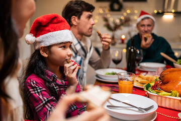 Multi-ethnic big family celebrating Christmas party together in house.