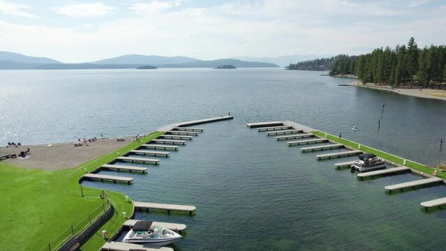 Aerial of a boat dock marina over lake with mountains in background