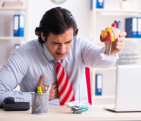 Young male employee suffering in the office