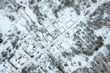 small village with snow-covered houses and road. winter landscape. aerial top view.