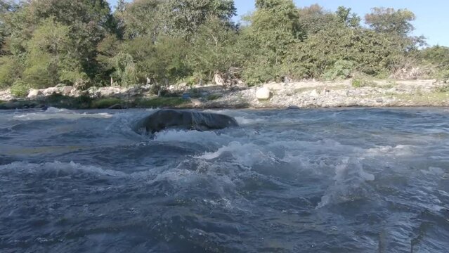 R&iacute;o monta&ntilde;oso salvaje que fluye a trav&eacute;s de rocas de piedra.