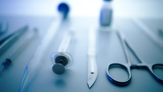 Medical instruments in steel tray on table for surgery. Preparing of surgical tools for a operation. Scalpels and forceps and tweezers. Surgery or emergency case and ambulance or treatment concept.