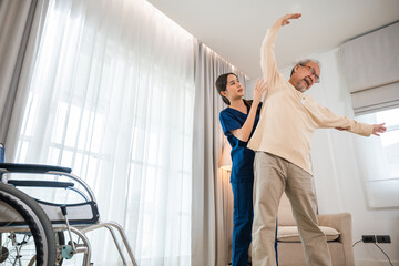 Old senior man enjoys training with physiotherapist for outstretched arms at home, Asian physical therapist patient nursing helping elderly exercising arm stretch, Rehabilitation of disabled concept