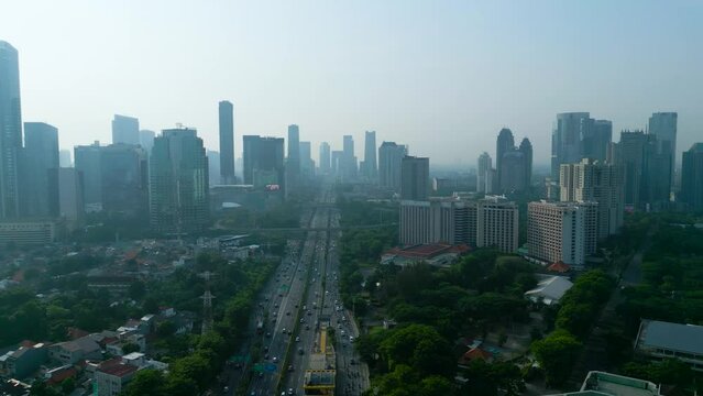 Aerial view of tollway traffic with misty skyscraper