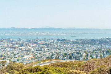 winding hillside road with ocean and city background