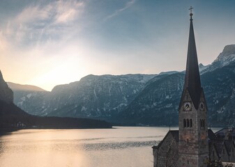Landscape of Hallstatt Lutheran Church tower by Lake and Austria Alps with cloudy sky in Austria