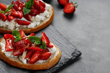 Toast with strawberries, cream cheese, ricotta cheese, honey, almond and mint. Sweet strawberry...